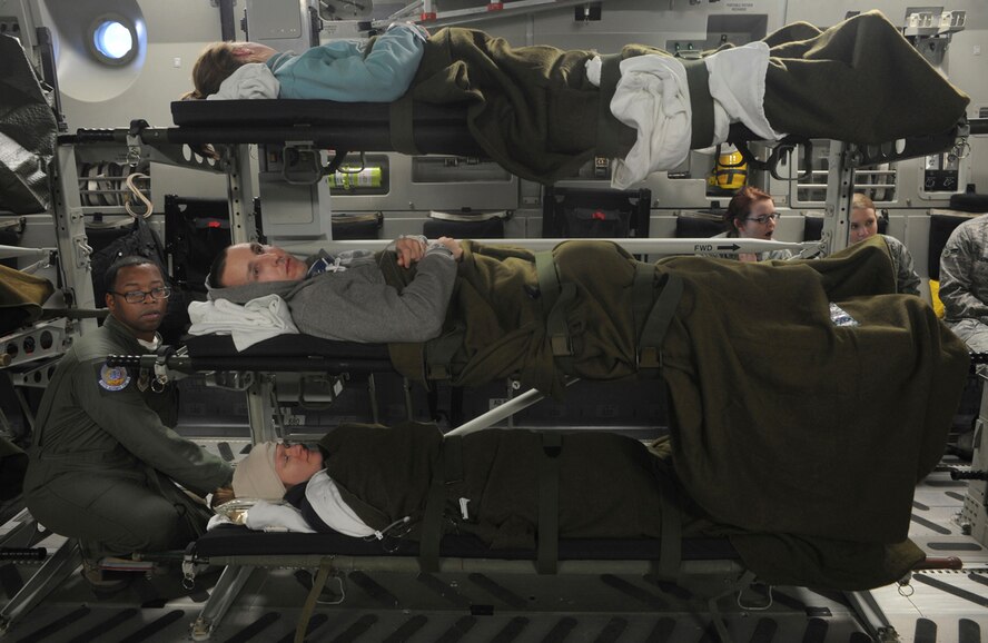 Air Force Staff Sgt. Errington Neysmith II, 375th Aeromedical Evacuation Squadron, prepares simulated natural disaster casualties for transport during an evacuation drill as part of Mission Assurance Exercise 14-3 at Joint Base Elmendorf-Richardson, Alaska, March 31, 2014. MAE 14-3 is a JBER exercise testing the base’s ability to survive, operate and coordinate during a major natural disaster.   (U.S. Air Force photo/Justin Connaher)