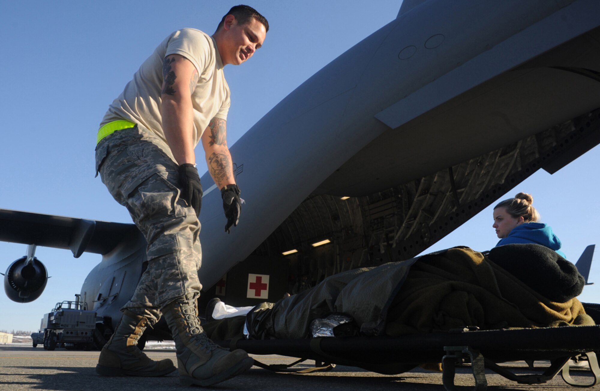 Air Force Staff Sgt. Jason Adrian, 60th Medical Group, Travis Air Force Base, Calif., checks the status of a simulated natural disaster casualty during an evacuation drill as part of Mission Assurance Exercise 14-3 at Joint Base Elmendorf-Richardson, Alaska, March 31, 2014. MAE 14-3 is a JBER exercise testing the base’s ability to survive, operate and coordinate during a major natural disaster.   (U.S. Air Force photo/Justin Connaher)
