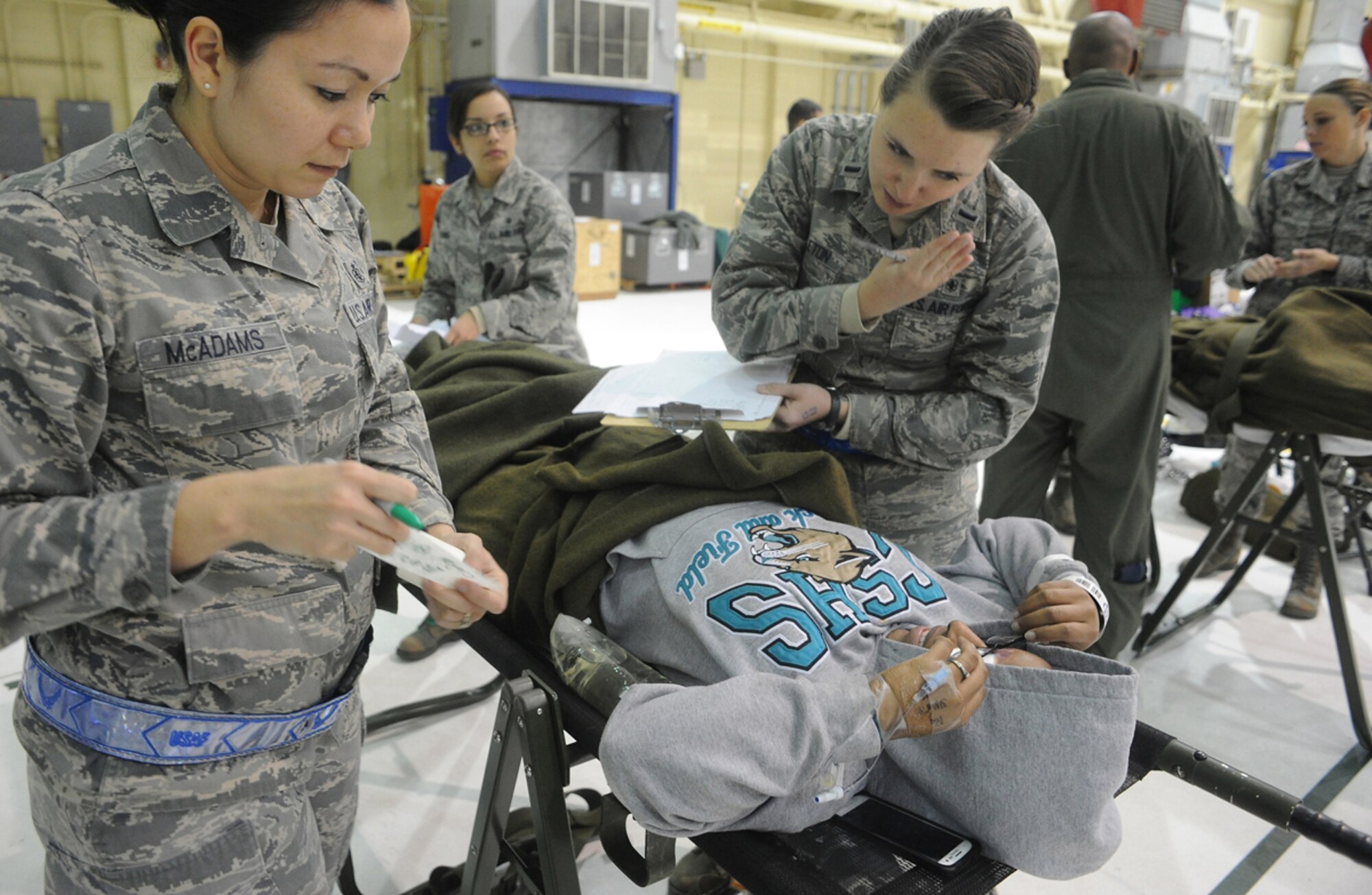 Air Force Staff Sgt. Rose McAdams, left, and 1st Lt. Samantha Stapleton, 673d Medical Group, prepare a simulated natural disaster casualty for transport during an evacuation drill as part of Mission Assurance Exercise 14-3 at Joint Base Elmendorf-Richardson, Alaska, March 31, 2014. MAE 14-3 is a JBER exercise testing the base’s ability to survive, operate and coordinate during a major natural disaster.   (U.S. Air Force photo/Justin Connaher)