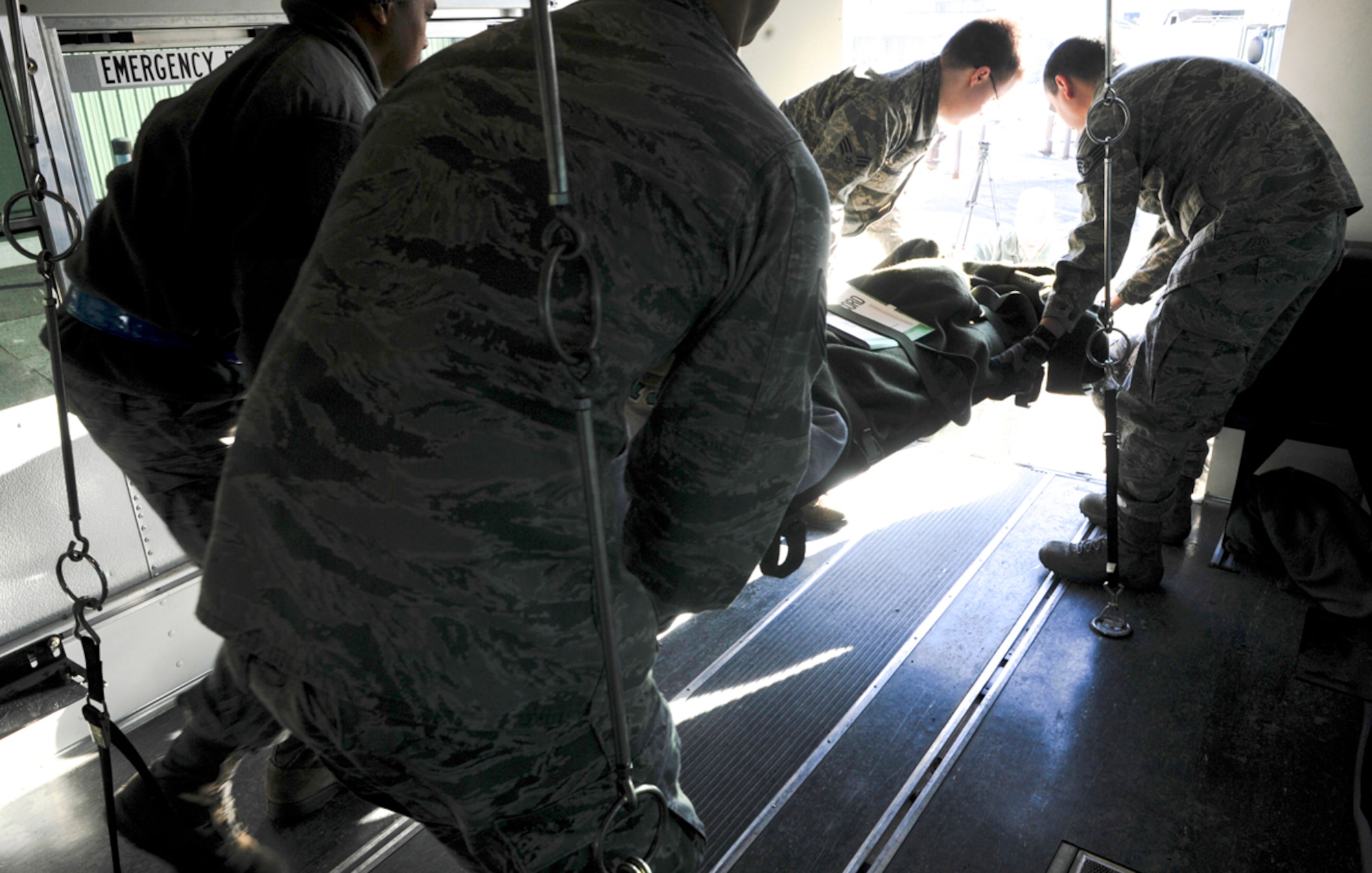 Airmen of the 673d Medical Group unload a simulated natural disaster casualty from an ambulatory bus for transport during an evacuation drill as part of Mission Assurance Exercise 14-3 at Joint Base Elmendorf-Richardson, Alaska, March 31, 2014. MAE 14-3 is a JBER exercise testing the base’s ability to survive, operate and coordinate during a major natural disaster.   (U.S. Air Force photo/Justin Connaher)