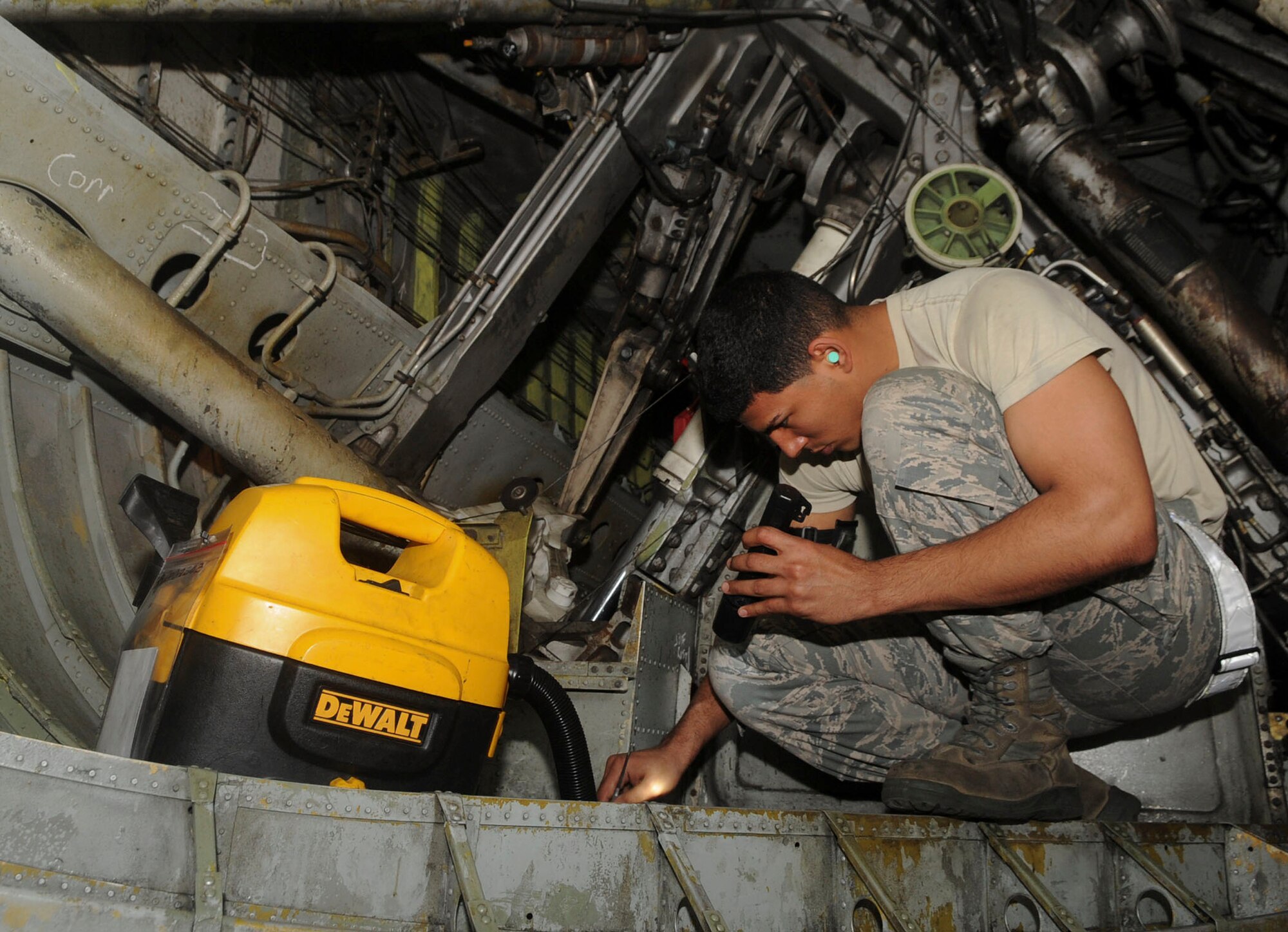 Senior Airman Angel Ducasse, 2nd Maintenance Squadron phase inspection journeyman, inspects and cleans the wheel-well of a B-52H Stratofortress on Barksdale Air Force Base, La., March 31, 2014. The wheel-well collects foreign object debris during take-off and landing and is cleaned out every 450 flying hours to prevent build-up. (U.S. Air Force photo/Senior Airman Kristin High)