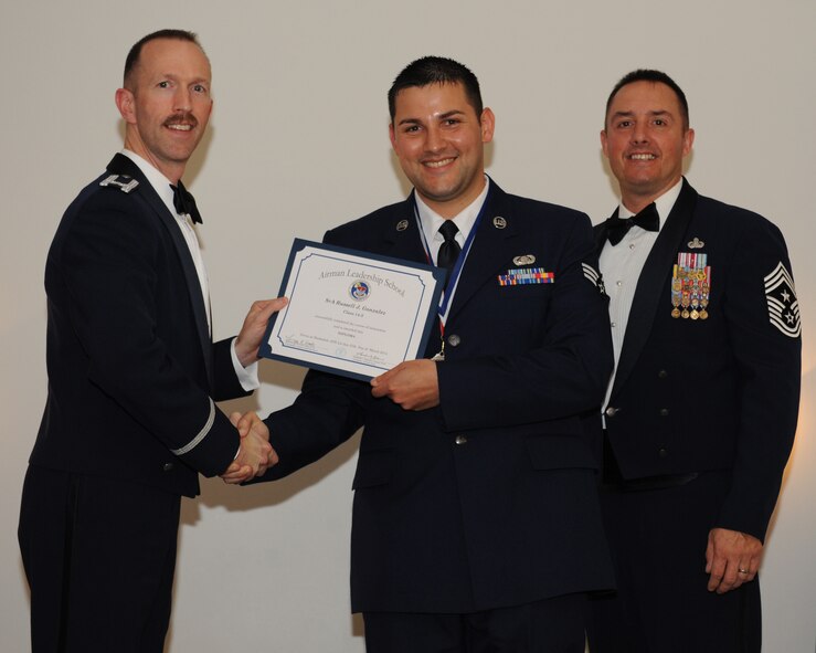 Senior Airman Russell Gonzalez, 548th Combat Training Squadron, receives an Airman Leadership School graduation certificate from Col. Leland Bohannon, 2nd Bomb Wing vice commander, during the ALS Class 14-3 Graduation on Barksdale Air Force Base, La., March 27, 2014. (U.S. Air Force photo/Senior Airman Benjamin Gonsier)