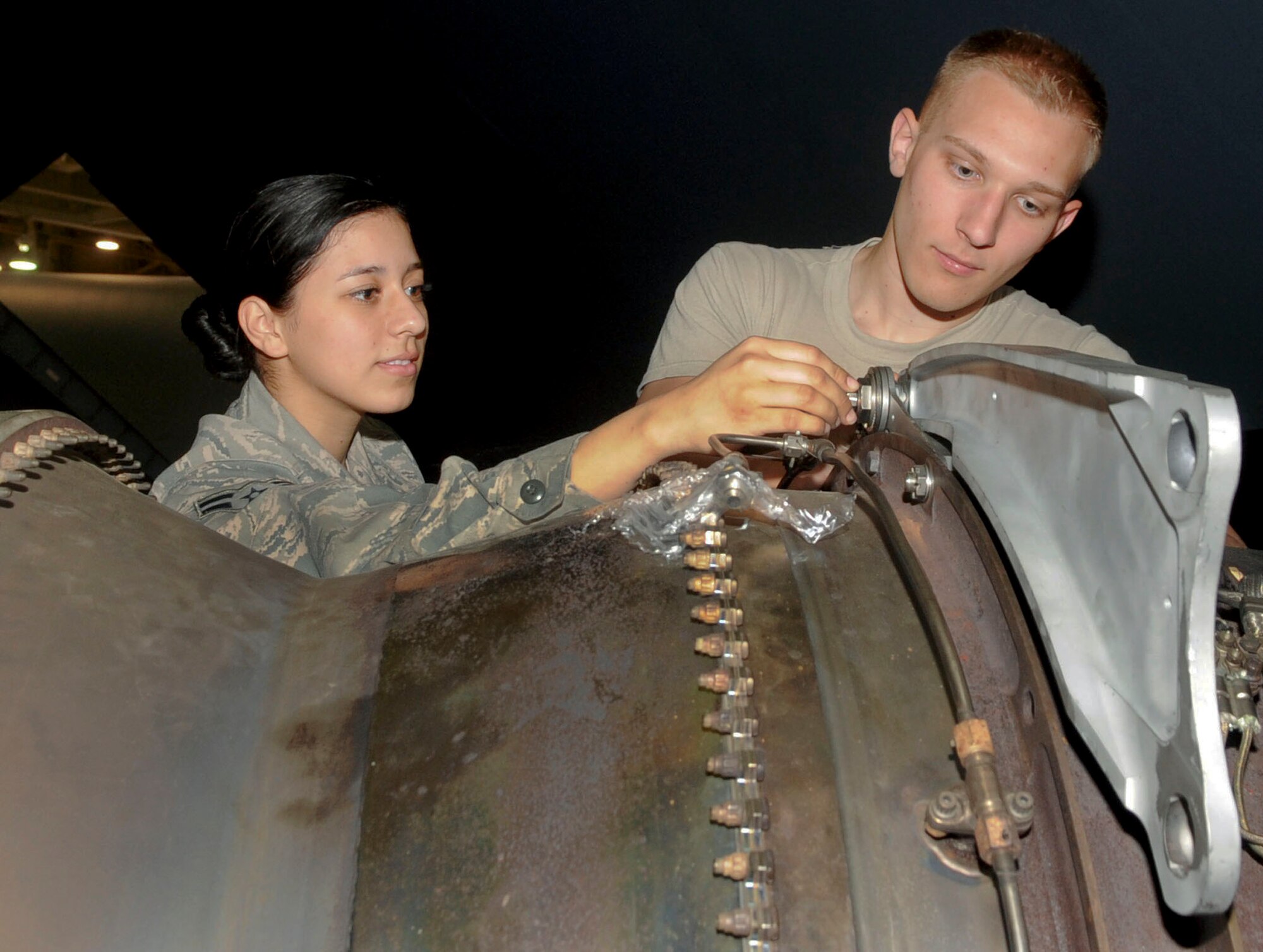 Airmen 1st Class Carmina Vazquez and Logan Farrar, 2nd Maintenance Squadron engine propulsion mechanics, install mounts onto an engine of a B-52H Stratofortress on Barksdale Air Force Base, La., March 31, 2014. The B-52H Stratofortress has a top speed of 650 mph and can carry up to 70,000 lbs of mixed ordnance such as bombs, mines and missiles. (U.S. Air Force photo/Senior Airman Kristin High)