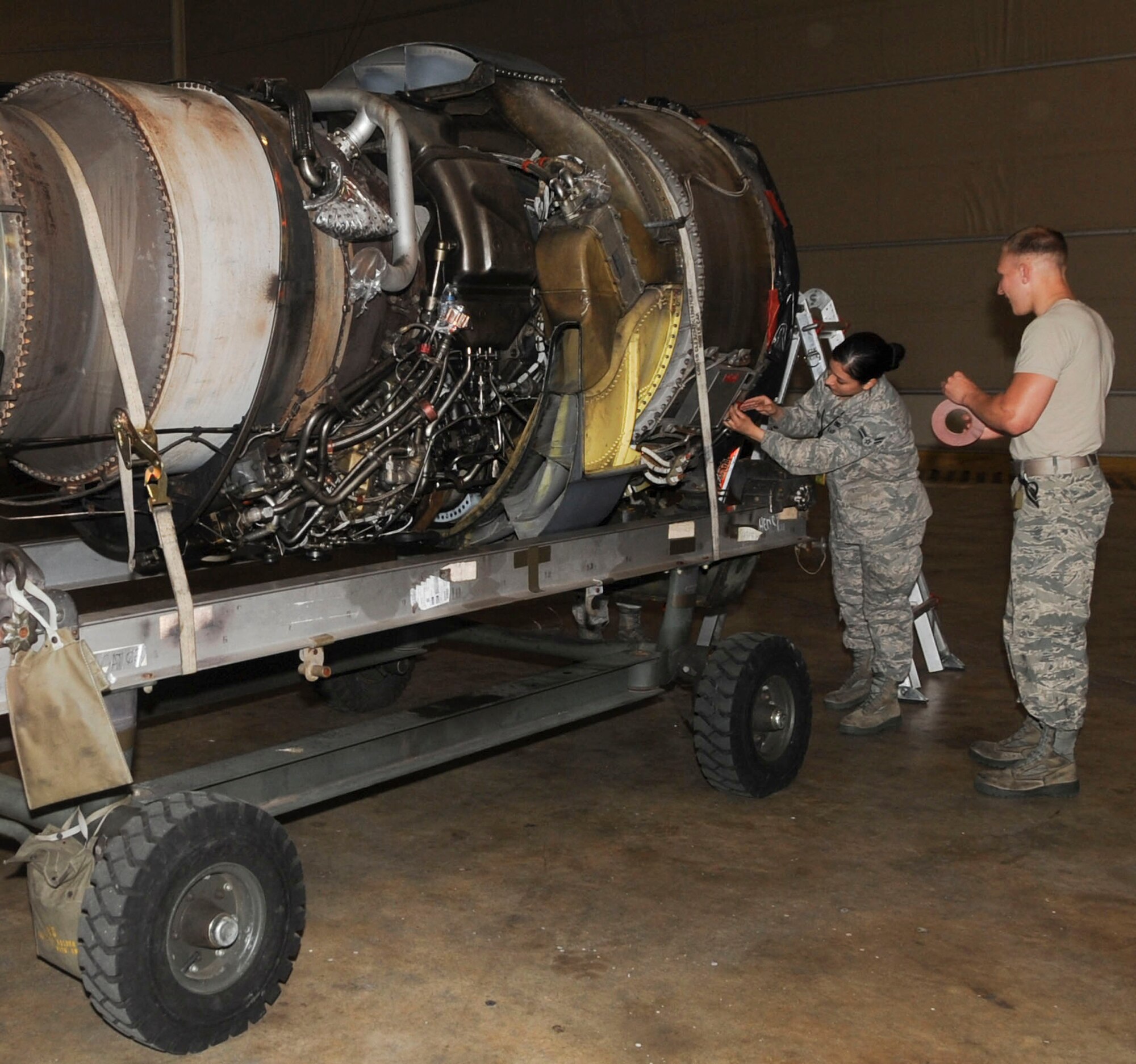 Airmen 1st Class Carmina Vazquez and Logan Farrar, 2nd Maintenance Squadron engine propulsion mechanics, tape a cover onto an engine of a B-52H Stratofortress on Barksdale Air Force Base, La., March 31, 2014. The cover prevents foreign object debris from entering the engine during transport. (U.S. Air Force photo/Senior Airman Kristin High)