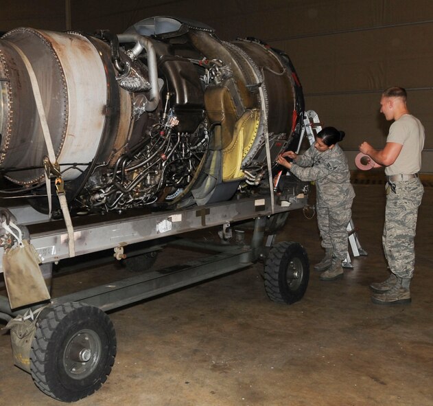 Airmen 1st Class Carmina Vazquez and Logan Farrar, 2nd Maintenance Squadron engine propulsion mechanics, tape a cover onto an engine of a B-52H Stratofortress on Barksdale Air Force Base, La., March 31, 2014. The cover prevents foreign object debris from entering the engine during transport. (U.S. Air Force photo/Senior Airman Kristin High)