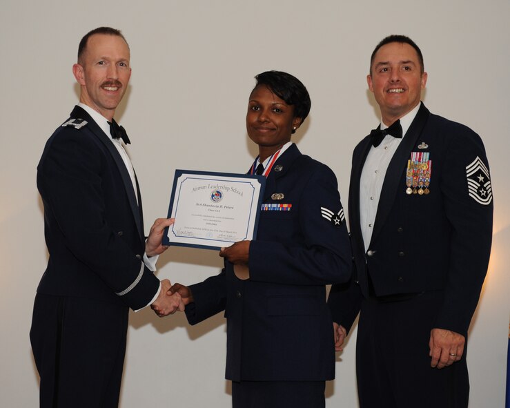 Senior Airman Shantavia Peters, 403rd Maintenance Group, Keesler Air Force Base, Miss., receives an Airman Leadership School graduation certificate from Col. Leland Bohannon, 2nd Bomb Wing vice commander, during the ALS Class 14-3 Graduation on Barksdale AFB, La., March 27, 2014. (U.S. Air Force photo/Senior Airman Benjamin Gonsier)