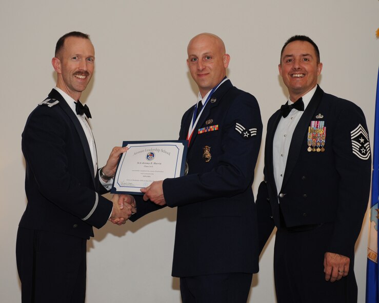 Senior Airman Jeremy Harris, 434th Security Forces Squadron, Grissom Air Reserve Base, Ind., receives an Airman Leadership School graduation certificate from Col. Leland Bohannon, 2nd Bomb Wing vice commander, during the ALS Class 14-3 Graduation on Barksdale Air Force Base, La., March 27, 2014. (U.S. Air Force photo/Senior Airman Benjamin Gonsier)