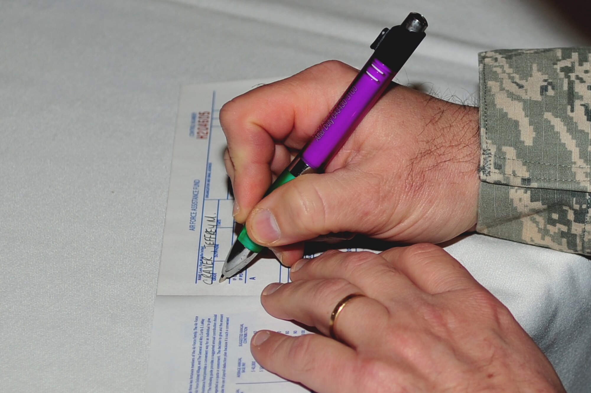 U.S. Air Force Chief Master Sgt. Jeffrey Craver, 4th Fighter Wing Command Chief, signs his commitment to caring at the Air Force Assistant Fund kickoff, March 24, 2014, at Seymour Johnson Air Force Base, N.C. The AFAF drive will run March 24 through May 2 to raise funds for a variety of programs that provide support ranging from financial assistance to care for military widows. (U.S. Air Force photo/Airman 1st Class Shawna L. Keyes)
