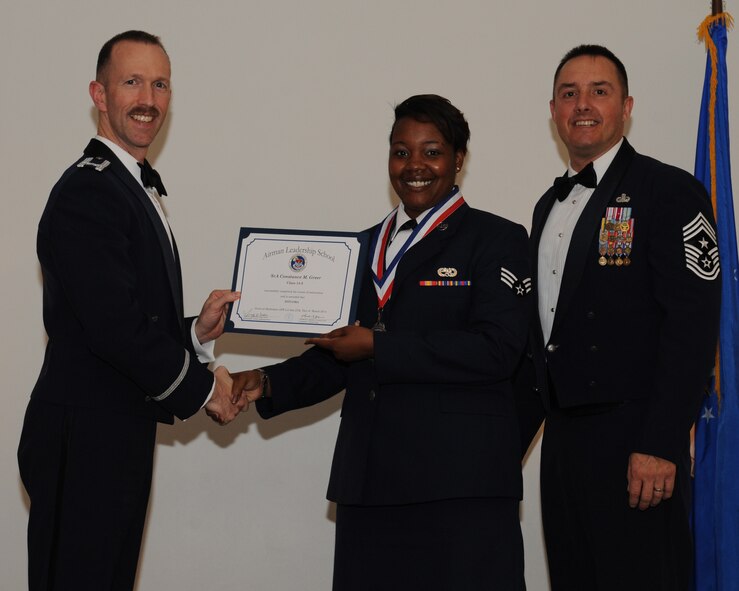 Senior Airman Constance Greer, 403rd Maintenance Group, Keesler Air Force Base, Miss., receives an Airman Leadership School graduation certificate from Col. Leland Bohannon, 2nd Bomb Wing vice commander, during the ALS Class 14-3 Graduation on Barksdale AFB, La., March 27, 2014. (U.S. Air Force photo/Senior Airman Benjamin Gonsier)