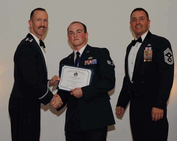 Senior Airman Tommy Lester, 2nd Security Forces Squadron, receives an Airman Leadership School graduation certificate from Col. Leland Bohannon, 2nd Bomb Wing vice commander, during the ALS Class 14-3 Graduation on Barksdale Air Force Base, La., March 27, 2014. (U.S. Air Force photo/Senior Airman Benjamin Gonsier)