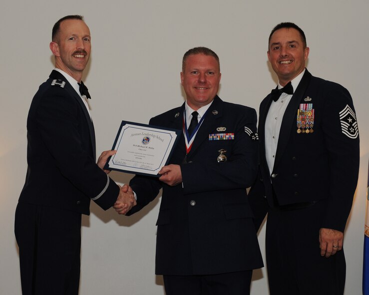 Senior Airman Michael Willis, 434th Security Forces Squadron, Grissom Air Reserve Base, Ind., receives an Airman Leadership School graduation certificate from Col. Leland Bohannon, 2nd Bomb Wing vice commander, during the ALS Class 14-3 Graduation on Barksdale Air Force Base, La., March 27, 2014. (U.S. Air Force photo/Senior Airman Benjamin Gonsier)
