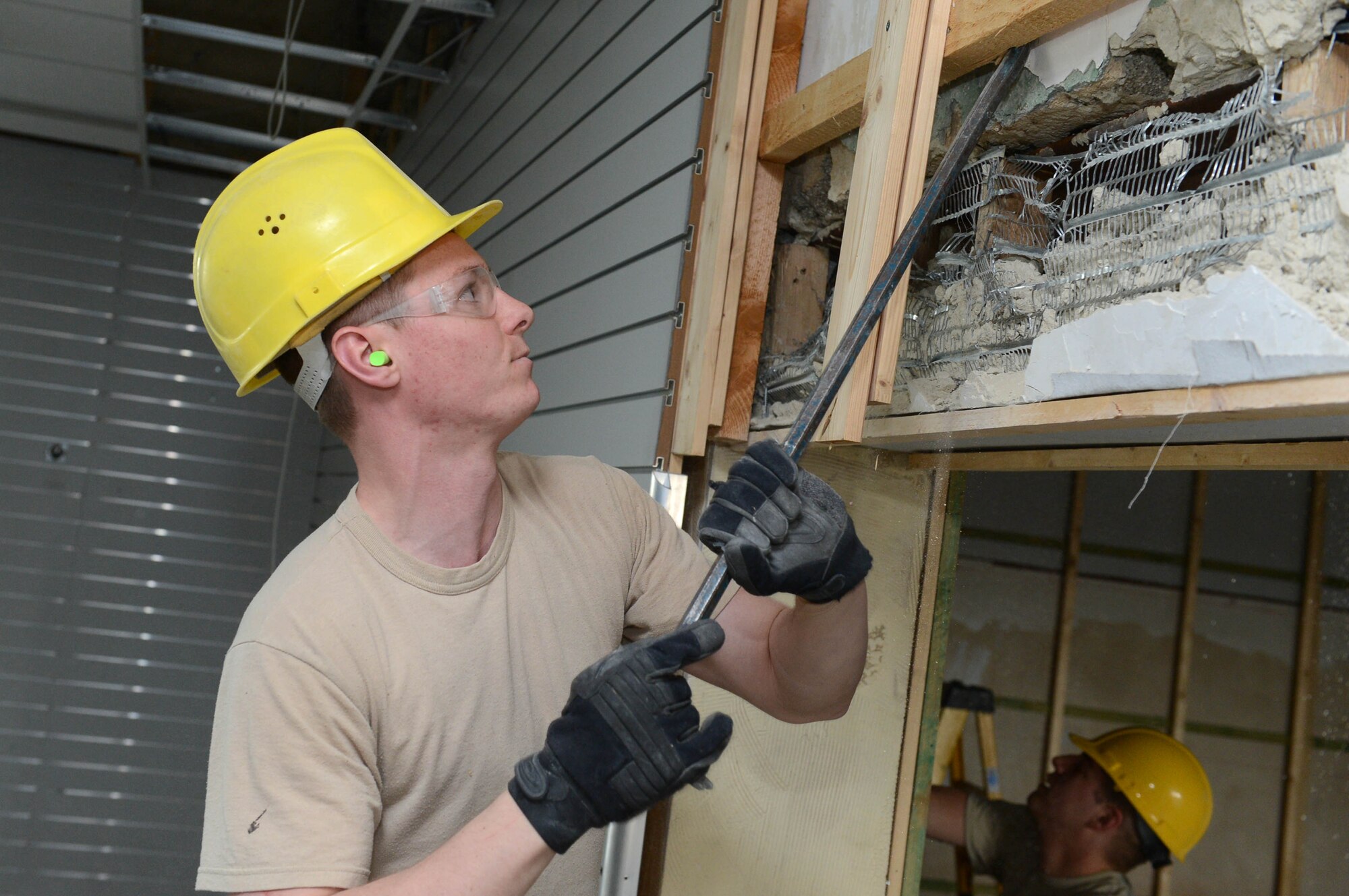 U.S. Air Force Airman 1st Class Daniel Webber, 52nd Civil Engineer Squadron structures shop from Lanesboro, Minn., removes a wall for a renovation project at Spangdahlem Air Base, Germany, April 1, 2014. Webber removed the wall to create enough clearance for a forklift. The unused building was renovated to make a storage facility for the furnishings management office. The office provides temporary housing supplies for Airmen who reside on and off-base. (U.S. Air Force photo by Airman 1st Class Kyle Gese/Released)
