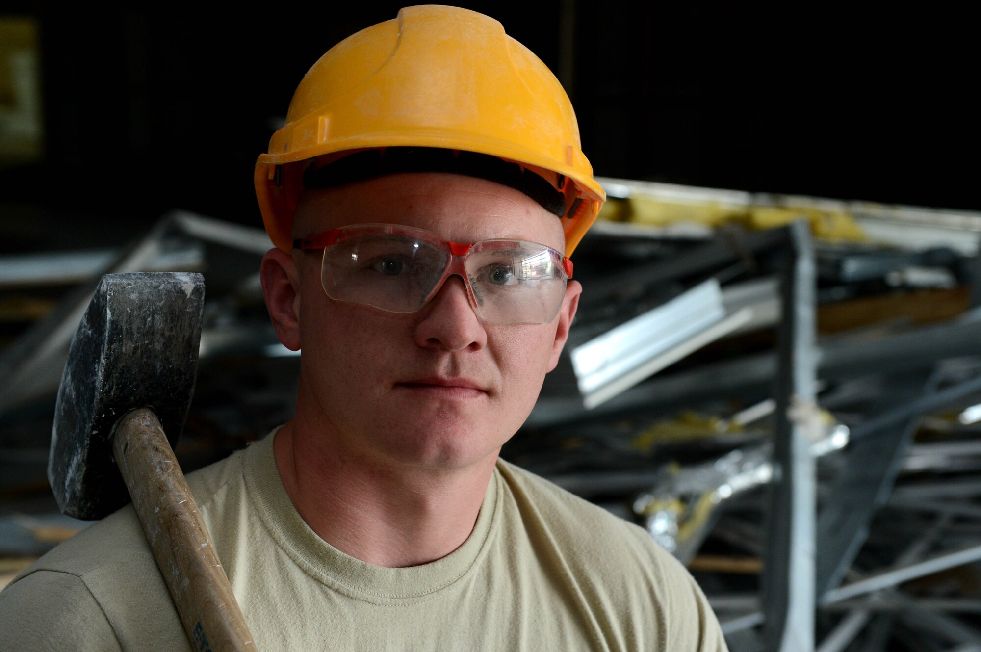 U.S. Air Force Senior Airman Eric Fick, 52nd Civil Engineer Squadron structures shop from Grandjunction, Colo., stands in front of scrap metal at Spangdahlem Air Base, Germany, April 1, 2014. The construction is part of a renovation project to consolidate temporary housing equipment to a building on base that saves Air Force money. (U.S. Air Force photo by Airman 1st Class Kyle Gese/Released)