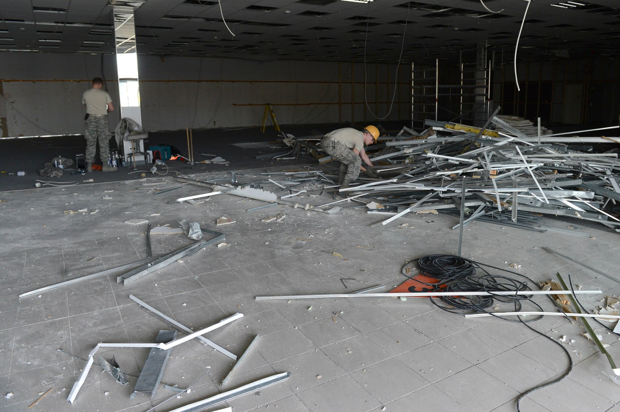 U.S. Air Force Airmen from the 52nd Civil Engineer Squadron structures shop, move scrap metal to a recycle bin outside an unused building at Spangdahlem Air Base, Germany, April 1, 2014. The renovated building will consolidate temporary housing equipment and give approximately three acres of land back to Germany. Giving the land back to Germany will save Air Force money associated with renting a separate location for storage. (U.S. Air Force photo by Airman 1st Class Kyle Gese/Released) 