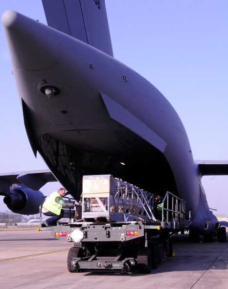Ministry of Defence workers from the 727th Air Mobility Squadron Air Freight section offload a boom for a KC-135 Stratotanker onto a K-loader from a C-17 Globemaster III March 12, 2014, on RAF Mildenhall, England. Air freight handlers from the 727th AMS regularly offload and upload cargo, including household goods, aircraft parts and general supplies from incoming and onto outgoing aircraft on a regular basis. (U.S. Air Force photo by Karen Abeyasekere/Released)