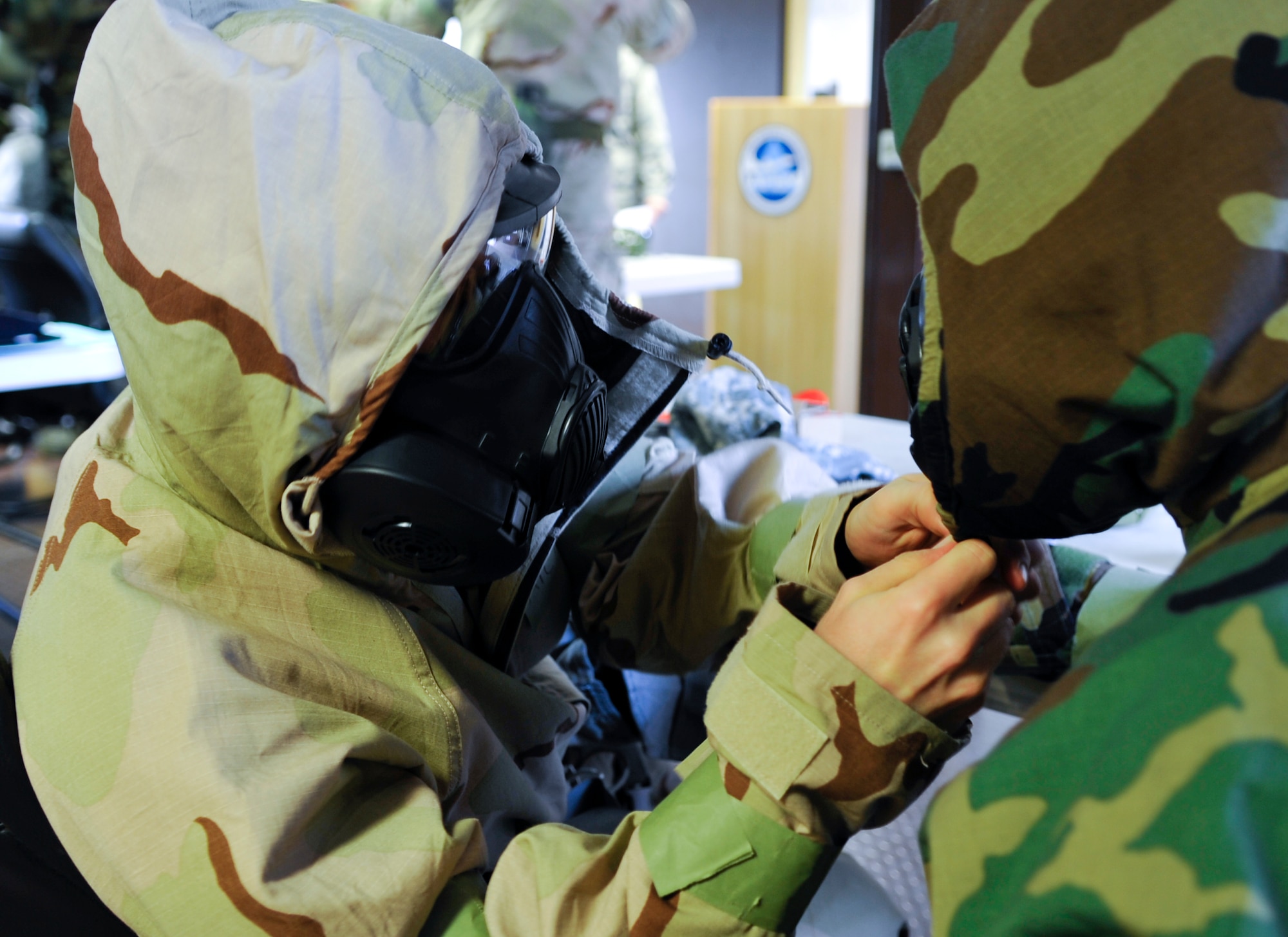 Airman 1st Class Ronald Mabry, 86th Maintenance Squadron crew chief, helps his wingman don his mission oriented protective posture gear March 3, 2014 at Ramstein Air Base, Germany. The chemical, biological, radiological and nuclear training course prepares Airmen for hostile environments. (U.S. Air Force photo/Airman Larissa Greatwood)