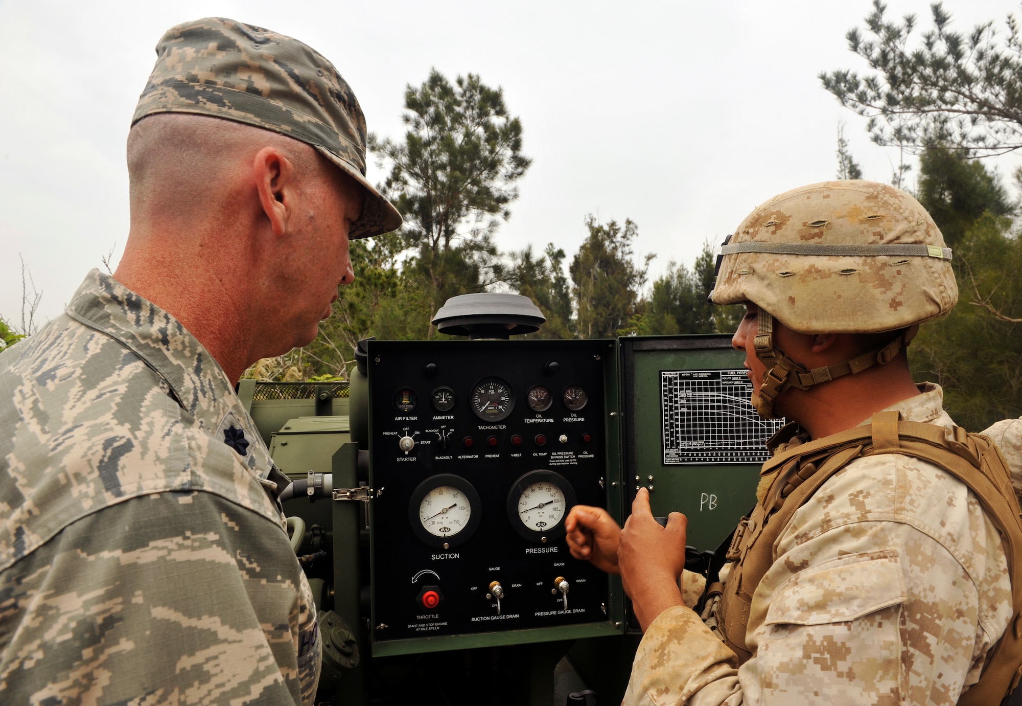 U.S. Marine Corps Lance Cpl. Hector Martinez, 9th Engineer Support Battalion bulk fuels technician, explains to U.S. Air Force Lt. Col. Craig Hodges, Pacific Air Forces chief of fuels and vehicle management, about the function of a 600-gallon per minute centrifugal pump during the USMC 9th ESB, Bulk Fuels Company, 1st Platoon Field Exercise on Camp Hansen, Okinawa, Japan, March 27, 2014. The training was conducted at the central training area in a tactical environment that encouraged exercising bulk fuel capabilities and basic combat skills. (U.S. Air Force photo by Naoto Anazawa)