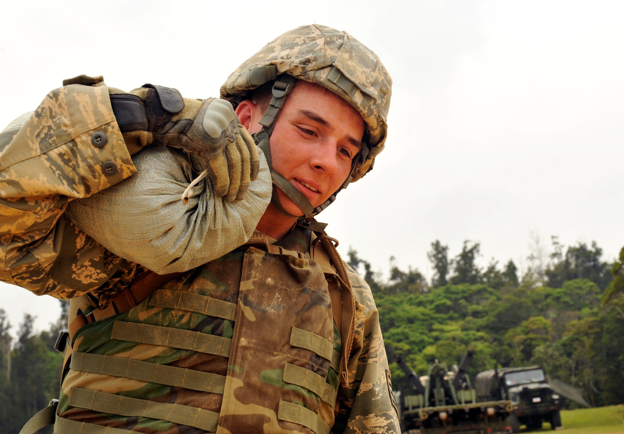 U.S. Air Force Staff Sgt. J Mack, 18th Logistics Readiness Squadron fuels supervisor, carries a sand bag during an exercise with U.S. Marine Corps 9th Engineer Support Battalion, Bulk Fuels Company, 1st Platoon on Camp Hansen, Japan, March 27, 2014. The exercise gave the Airmen an opportunity to train with various fuel systems in the employment of bare-based operations. (U.S. Air Force photo by Naoto Anazawa)