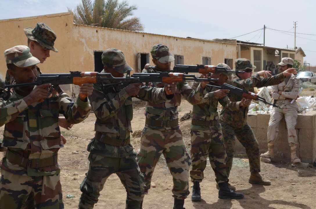 Lance Cpl. Forrest Maness and Pfc. Michael Kelly, both Marines with Special-Purpose Marine Air-Ground Task Force Africa 14.1, demonstrate marksmanship positions to the Mauritanian Fusiliers Marins, Feb. 21, 2014, in Rosso, Mauritania. The theater security cooperation team was in Mauritania to train and advise their counterparts, the Fusiliers Marins, on infantry skills, marksmanship, patrolling skills, first aid and combat lifesaving skills, small boat operations and mission planning for leadership.