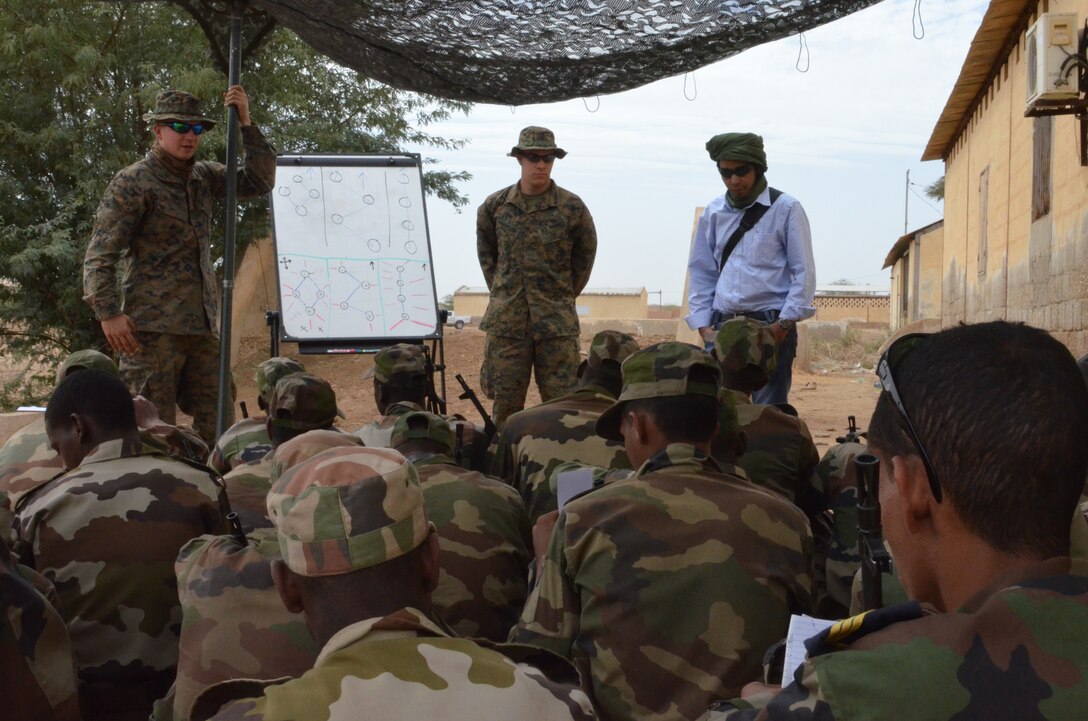 Lance Corporals Fletcher McGuire and Mickey Anderson, both Marines with Special-Purpose Marine Air-Ground Task Force Africa 14.1, give a period of instruction on fire team formations to the Mauritanian Fusiliers Marins, Feb. 22, 2014, in Rosso, Mauritania. The theater security cooperation team was in Mauritania to train and advise their counterparts on infantry skills, marksmanship, patrolling skills, first aid and combat lifesaving skills, small boat operations and mission planning for leadership.