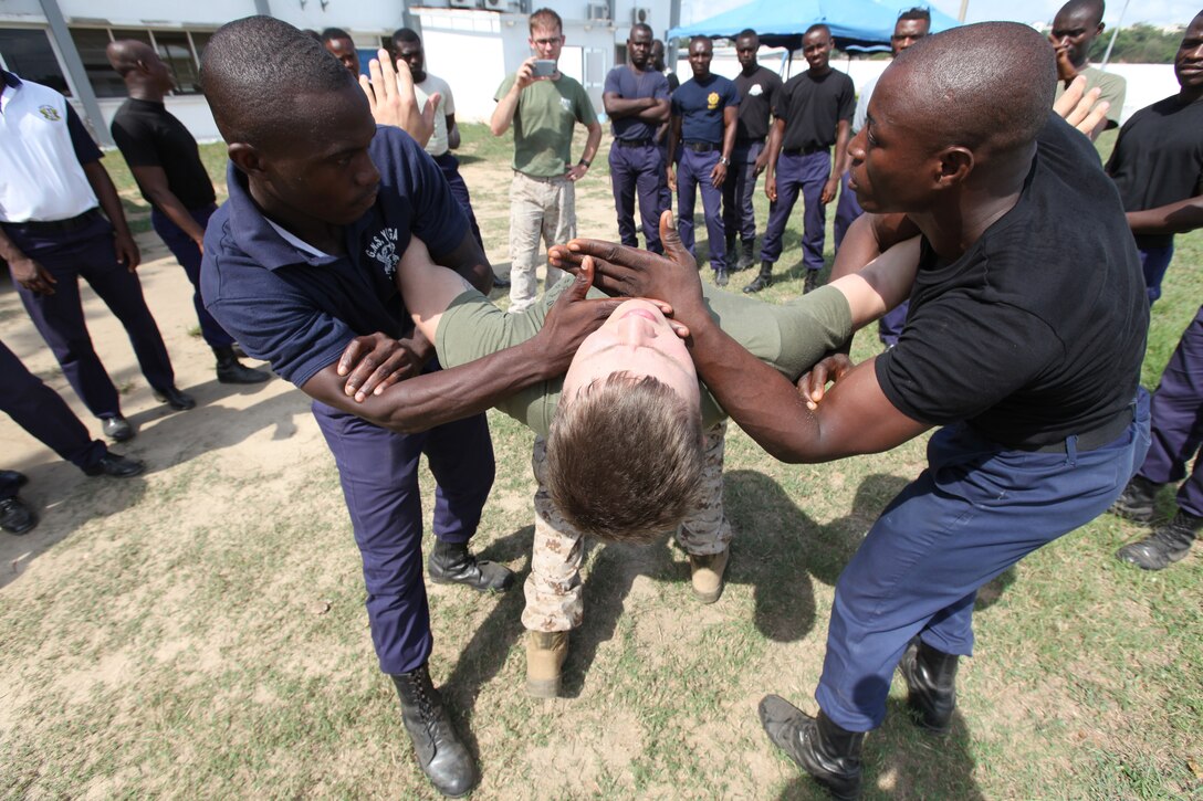Lance Cpl. Dewayne Gregory, a Marine with Special-Purpose Marine Air-Ground Task Force Africa 14.1, plays to role of a violent rioter being detained by two Ghanaian sailors in Takoradi, Ghana, March 20. A team of Marines demonstrated techniques that focused on the force continuum, or how to escalate the use of force for a given scenario, non-lethal ammunition and vehicle arresting devices during a week-long non-lethal weapons tactics course in order to promote and strengthen the ability to conduct good governance and development.