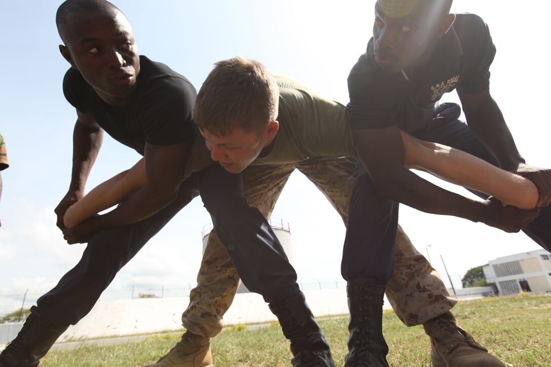 Lance Cpl. Dewayne Gregory, a Marine with Special-Purpose Marine Air-Ground Task Force Africa 14.1, plays to role of a violent rioter being detained by two Ghanaian sailors in Takoradi, Ghana, March 20. A team of Marines demonstrated techniques that focused on the force continuum, or how to escalate the use of force for a given scenario, non-lethal ammunition and vehicle arresting devices during a week-long non-lethal weapons tactics course in order to promote and strengthen the ability to conduct good governance and development.