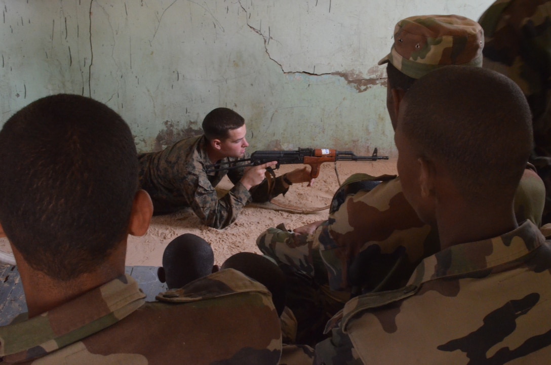 Pfc. Michael Kelly, a Marine with Special-Purpose Marine Air-Ground Task Force Africa 14.1 and a native of Philadelphia, instructs the Mauritanian Fusiliers Marins on proper shooting techniques, Feb. 21, 2014, in Rosso, Mauritania. The theater security cooperation team was in Mauritania to train and advise their counterparts, the Fusiliers Marines, on infantry skills, marksmanship, patrolling skills, first aid and combat lifesaving skills, small boat operations and mission planning for leadership.