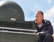 Marine Corps Tactical Systems Support Activity technical support officer and Marine Corps Tester of the Year Scot Hoesly surveys the Network-on-the-Move KU satellite communications antenna housing mounted aboard an Assault Amphibious Vehicle. Hoesly directs MCTSSA's testing of the NOTM/AAV platform that, when fielded, will provide a significantly new amphibious command-and-control capability to the Marine Corps. 
