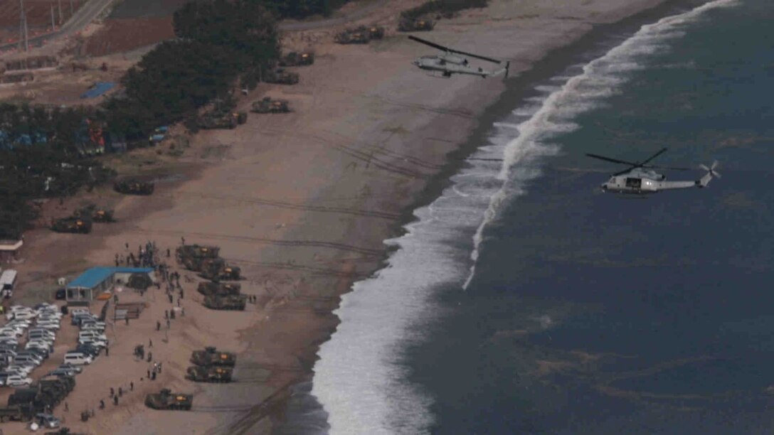 A U.S. Marine Corps UH-1Y Huey and AH-1Z Super Cobra fly over the beach following an amphibious assault during Ssang Yong 14 at Doksu-Ri, Pohang, South Korea, March 31, 2014. Exercise Ssang Yong is conducted annually in the Republic of Korea (ROK) to enhance the interoperability of U.S. and ROK forces by performing a full spectrum of amphibious operations while showcasing sea-based power projection in the Pacific. (Official U.S. Marine Corps photo by Cpl. David Gonzalez/Released)