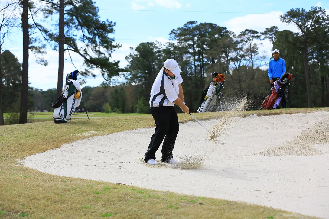Ben Lukehart, a golfer from Stevenson University, hits his ball out of a sand trap at the 43rd annual Marine Federal Credit Union Intercollegiate Golf Championship at the Paradise Point Golf Course aboard Marine Corps Base Camp Lejeune, March. 28. The 52-hole tournament was shortened to 36-holes due to inclement weather flooding the fairways Saturday.