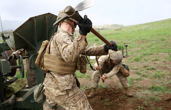 Marines with India Battery, 1st Battalion, 11th Marine Regiment, dig a trench to properly emplace the M777A2 Howitzer during a battalion fire exercise aboard Marine Corps Base Camp Pendleton, Calif., March 27, 2014. Once emplaced, the weapon system can accurately engage targets from 18 miles away. (U.S. Marine Corps photo by Lance Cpl. Jonathan Boynes/released)