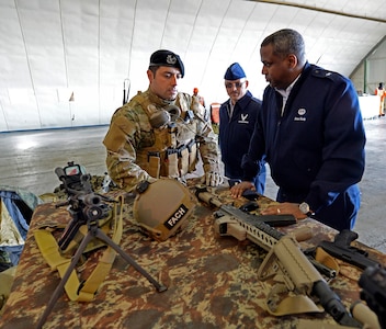 Chilean Air Force Capt. Javier Salinas, left, Commandos, 6th Squadron, 4th Aviation Brigade, Chilean Air Force, briefs U.S. Air Force Brig. Gen. Brian Newby, Chief of Staff and Vice Commander, Texas Air National Guard, and Command Chief Master Sgt. Oscar Tey, Senior Enlisted Leader, Texas Joint Domestic Operations Command, on the capabilities of his unit at the brigade's air base in southern Chile, March 27, 2014. 