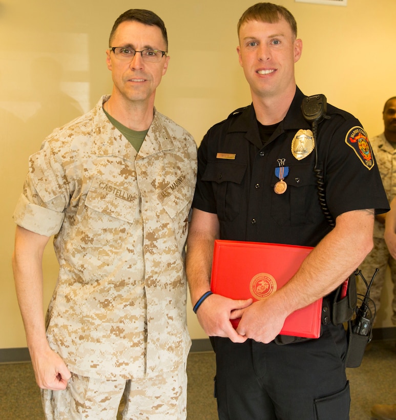Brig. Gen. Robert F. Castellvi, the commanding general of Marine Corps Installations East – Marine Corps Base Camp Lejeune, stands with Jarret White, a police officer with the Provost Marshal’s Office, after awarding him with a Commendation for Meritorious Civilian Service aboard Marine Corps Base Camp Lejeune, March 24. White was recognized for pulling a motorist out of a submerged vehicle on Wilmington Highway during a winter storm, on Jan. 28. By showing selflessness, quick-thinking and sound judgment, White, a Marine Corps veteran, showcased the traits Marines have used on the battlefield for more than 200 years, said Castellvi. “When you saw danger you jumped in, you saved somebody’s life and you made our Corps proud and our community proud,” said Castellvi.