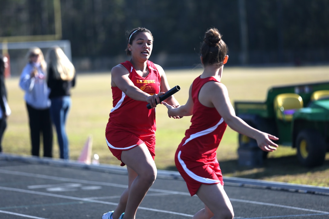 Abigail Miller passes the baton to Sonya Pantoja of the Lejeune High School track team pass the baton during a relay race at Lejeune High School aboard Marine Corps Base Camp Lejeune, March 27. The Lejeune girls track team competed against Jones High School and Southside High School. Lejeune won the meet with a final score of 108. Lejeune High School girls track coach, Debbie Bryant, said the female track and field participants put forth their best effort each track meet.