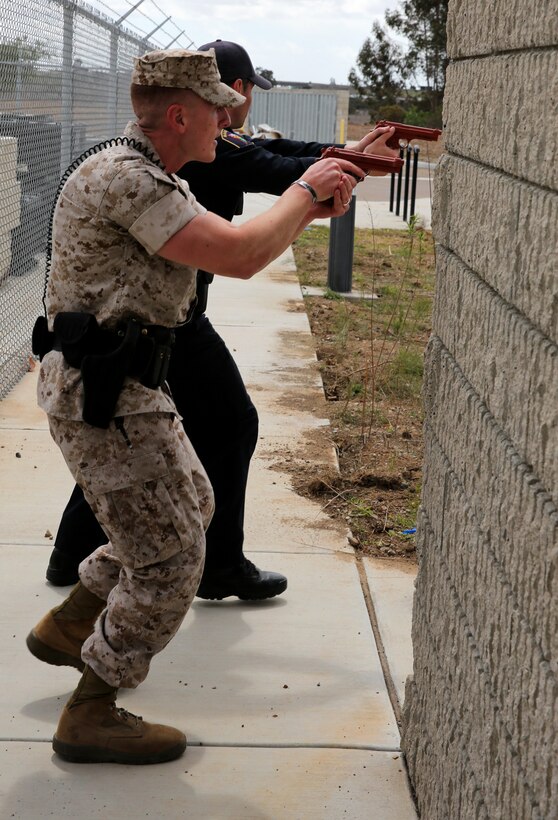 Sgt. Taylor Sanchez and Officer Jason Frederickson, both police officers with the Marine Corps Air Station Miramar Provost Marshal’s Office, tactically turn a corner in pursuit of an acting suspect during an active shooter exercise at the Navy Marine Reserve Center aboard MCAS Miramar, Calif., April 2. The officers cleared rooms in search of the threat before apprehending the acting suspect moments later.  