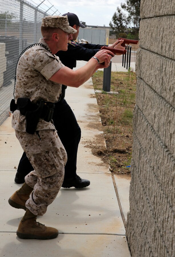 Sgt. Taylor Sanchez and Officer Jason Frederickson, both police officers with the Marine Corps Air Station Miramar Provost Marshal’s Office, tactically turn a corner in pursuit of an acting suspect during an active shooter exercise at the Navy Marine Reserve Center aboard MCAS Miramar, Calif., April 2. The officers cleared rooms in search of the threat before apprehending the acting suspect moments later.  