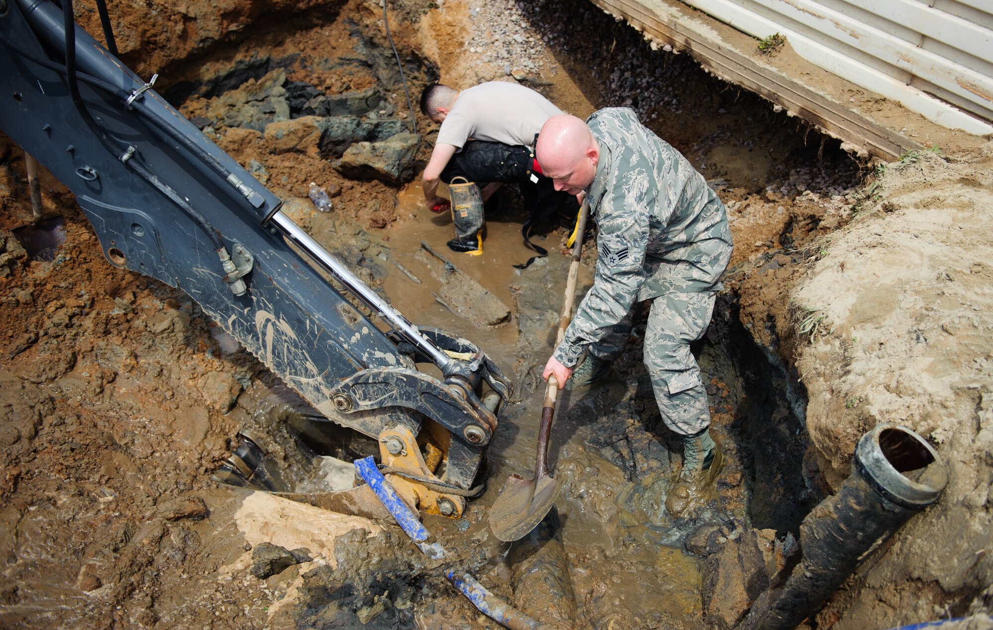 Senior Airman Casey Reed, 8th Civil Engineer Squadron water and fuel systems maintenance shop technician, removes mud from the area around a broken pipe at Kunsan Air Base, Republic of Korea, April 3, 2014. Reed and the 8th CES identified and began repairing the broken pipe within seven hours. (U.S. Air Force photo by Senior Airman Armando A. Schwier-Morales) 