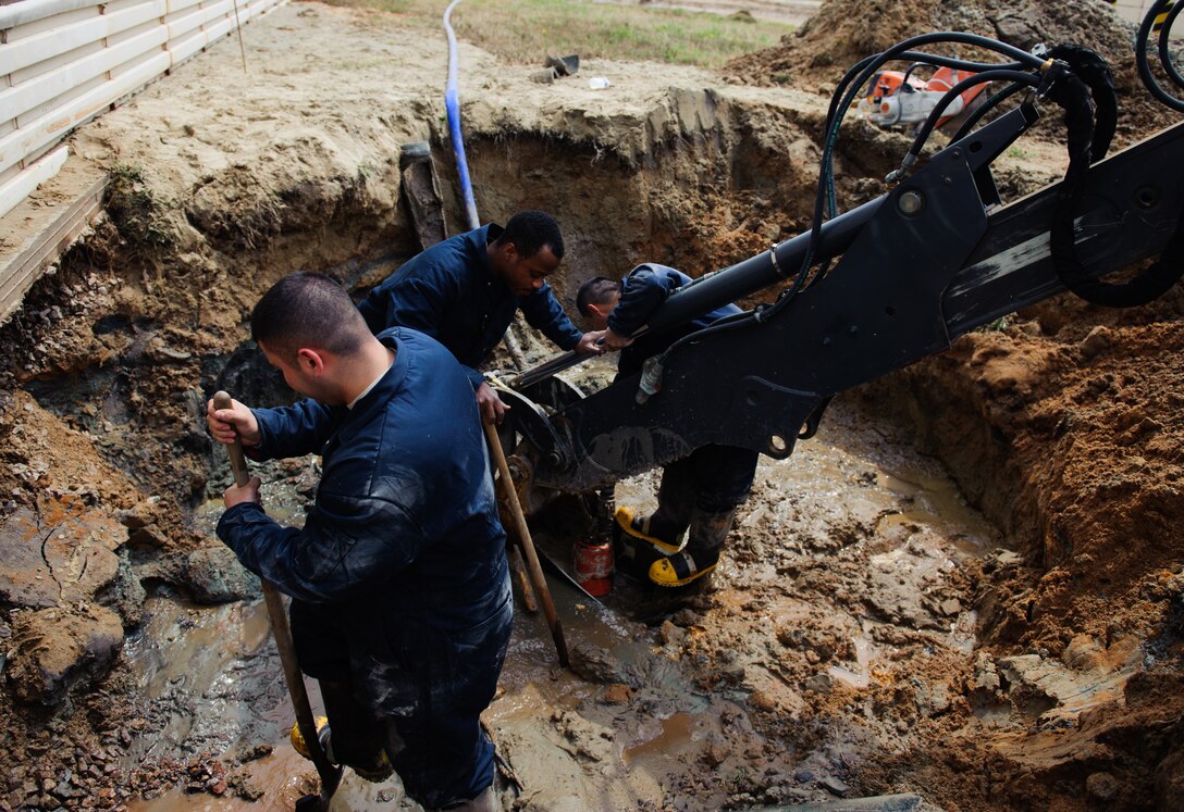 Senior Airman Apolonio Arreola, 8th Civil Engineer Squadron water and fuel systems maintenance shop technician, left, Senior Airman Theodore Anderson, 8th CES water and fuel systems maintenance shop technician, and Senior Airman Guzman Ayala, 8th CES water and fuel systems maintenance shop technician, clean the surrounding area of a broken water pipe at Kunsan Air Base, Republic of Korea, April 3, 2014. Reed and the 8th CES identified and began repairing the broken pipe within seven hours. (U.S. Air Force photo by Senior Airman Armando A. Schwier-Morales) 