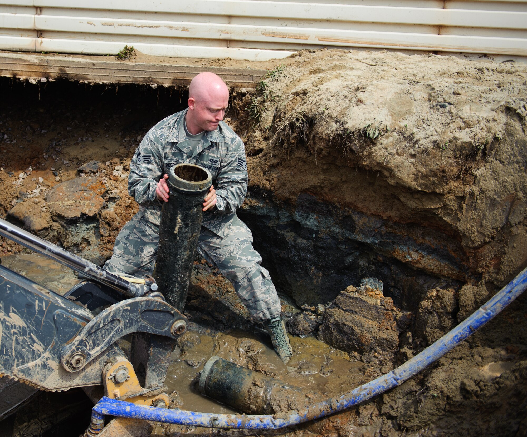 Senior Airman Casey Reed, 8th Civil Engineer Squadron water and fuel systems maintenance shop technician, removes a cast iron pipe after it was discovered broken at Kunsan Air Base, Republic of Korea, April 3, 2014. Reed and the 8th CES identified and began repairing the broken pipe within seven hours. (U.S. Air Force photo by Senior Airman Armando A. Schwier-Morales) 