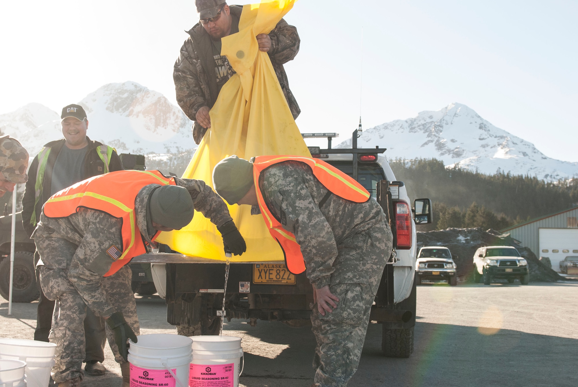 Local volunteers work with National Guard members of the 1/297 Alpha troop out of Anchorage, Alaska, to fill five gallon buckets of desalinated potable water at the towns Point of Distribution for Alaska Shield 14 here, on March 29, 2014. Alaska Shield 14 is an exercise that involves state, federal, military and local agencies, designed to test the response and coordination of the disaster modeled after the 1964 earthquake and subsequent tsunami that devastated much of South Central Alaska including the city of Cordova. (U.S. Army photo by Spc. Lindsey Schulte)