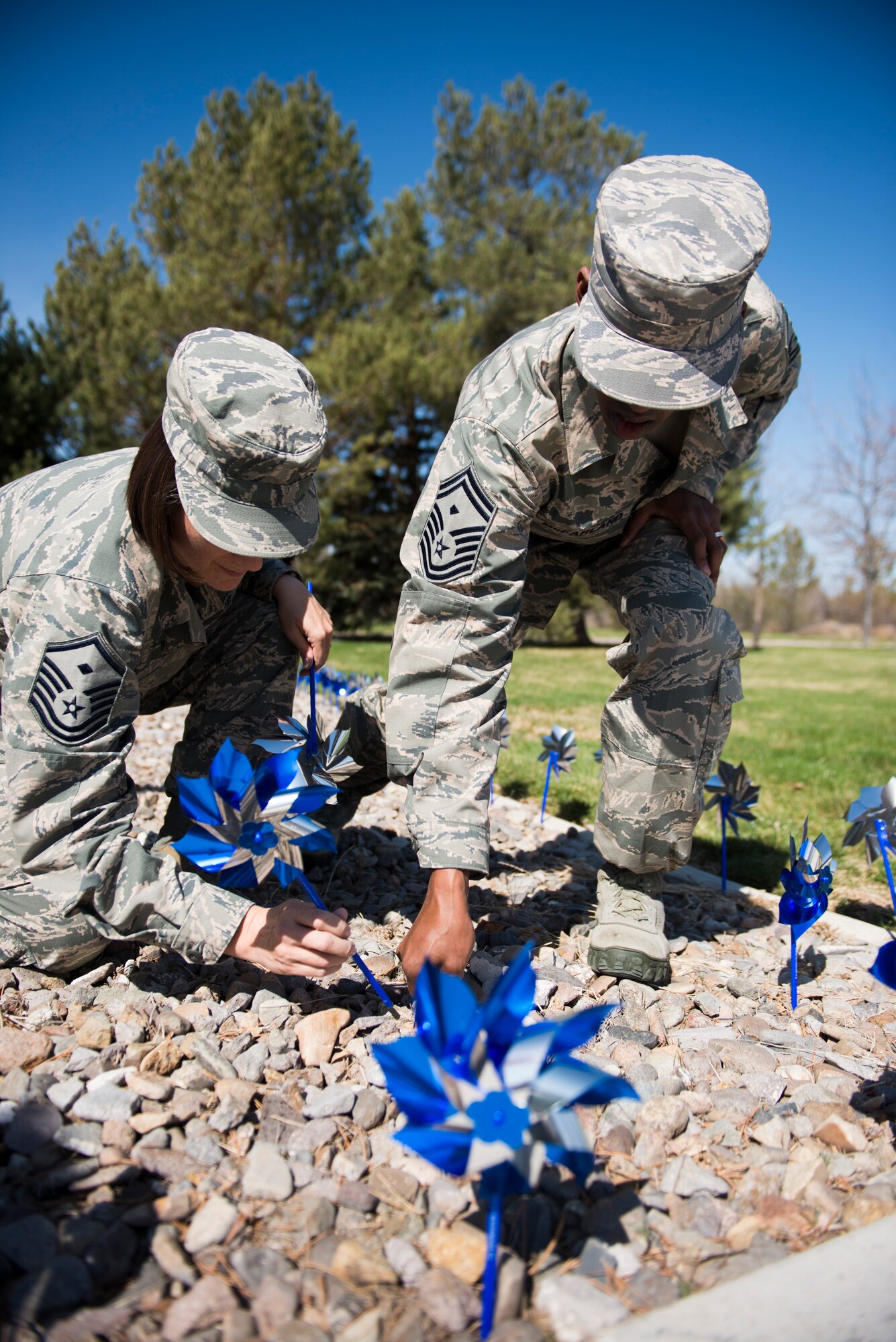 Master Sgt. Kathleen May, 366th Force Support Squadron first sergeant, and Senior Master Sgt. Brian McFarland, 366th Civil Engineer first sergeant, plant pinwheels at Mountain Home Air Force Base, Idaho, April 3, 2014. First sergeants and other volunteers planted pinwheels to show support during Prevent Child Abuse Month. (U.S. photo by Airman 1st Class Malissa Lott/RELEASED)