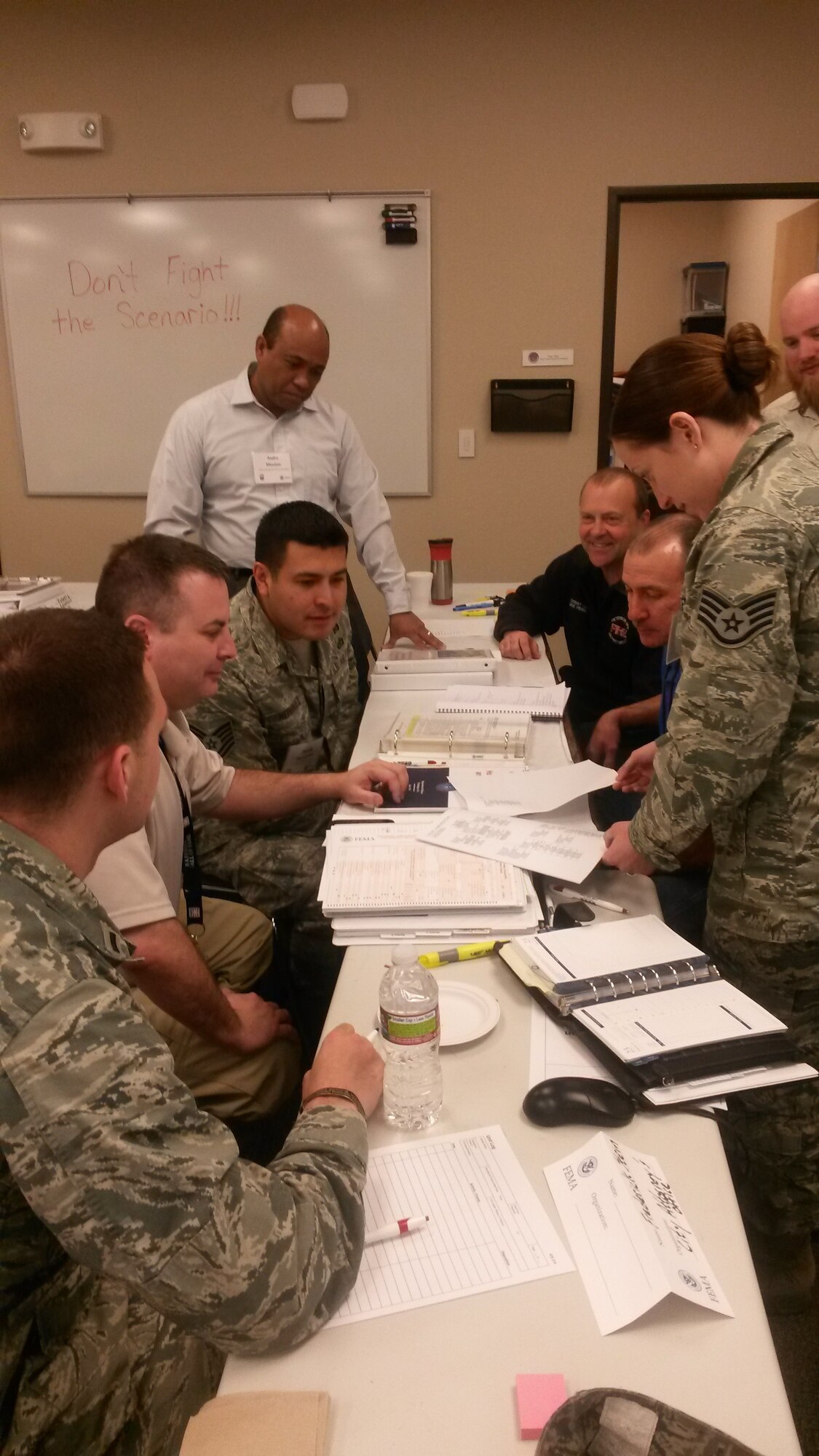Members from the U.S. Air Force Academy, Schriever Air Force Base and Peterson AFB discuss the current scenario with Douglas Kahn, a Federal Emergancy Management Agency instructor, during the final day of a four-day course used to train and test a communities preparedness March 22. Numerous Colorado Springs city and El Paso county departments convened in Colorado Springs for a four-day integrated emergency management course that culminated in testing the communities response to multiple and varied accidents and incidents during an exercise. 