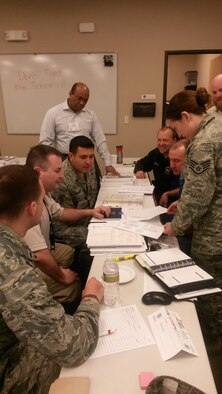 Members from the U.S. Air Force Academy, Schriever Air Force Base and Peterson AFB discuss the current scenario with Douglas Kahn, a Federal Emergancy Management Agency instructor, during the final day of a four-day course used to train and test a communities preparedness March 22. Numerous Colorado Springs city and El Paso county departments convened in Colorado Springs for a four-day integrated emergency management course that culminated in testing the communities response to multiple and varied accidents and incidents during an exercise. 