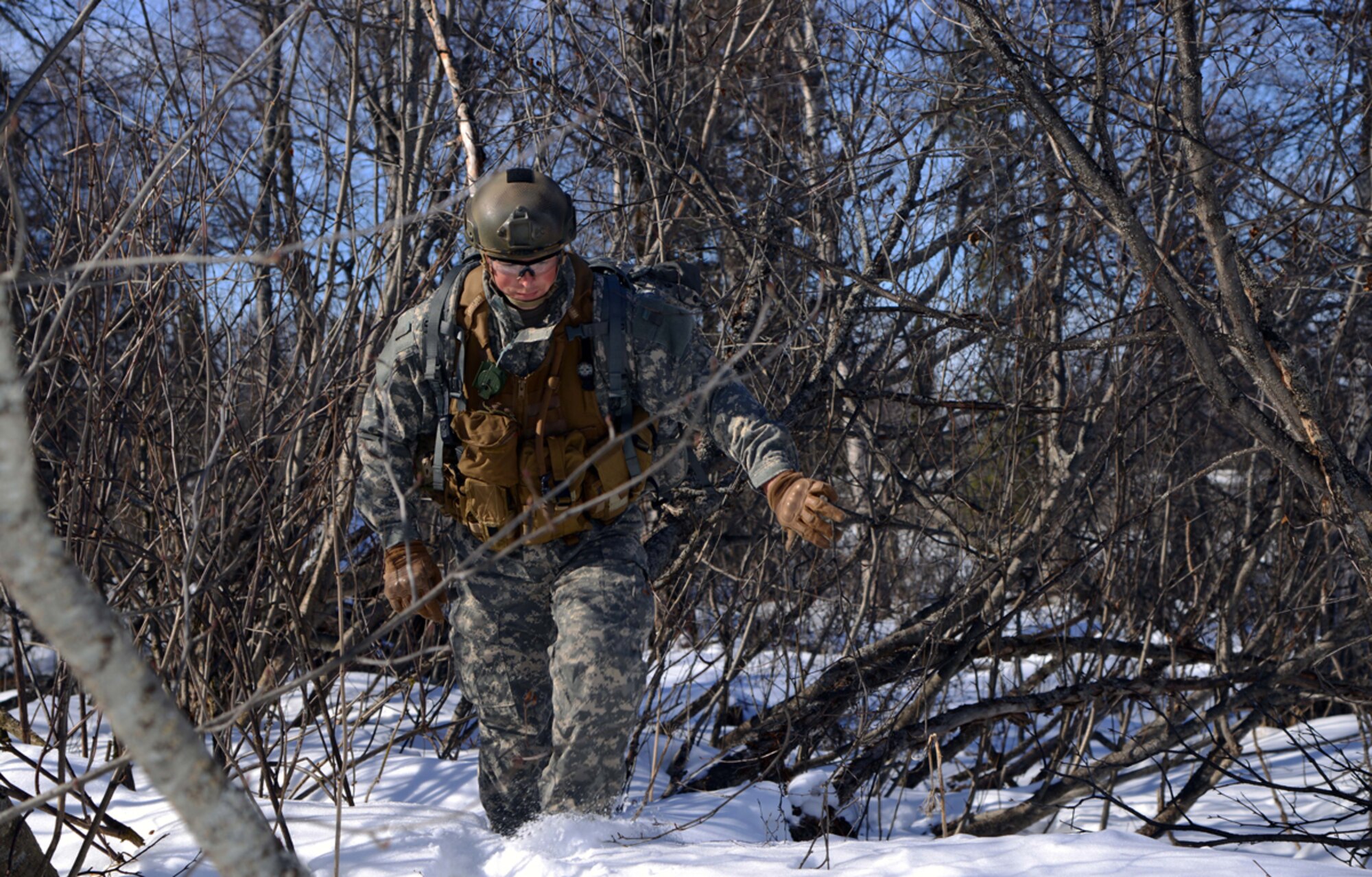 Air Force Staff Sgt. Travis Hunt, 3rd Air Support Operations Squadron joint terminal attack controller, finds his way through the woods during the Army's Warrior Leadership Course land navigation at Joint Base Elmendorf-Richardson, Alaska, March 26, 2014. The land navigation is designed for students to successfully navigate and locate given plot points using a map and compass. (U.S. Air Force photo/Staff Sgt. Sheila deVera)