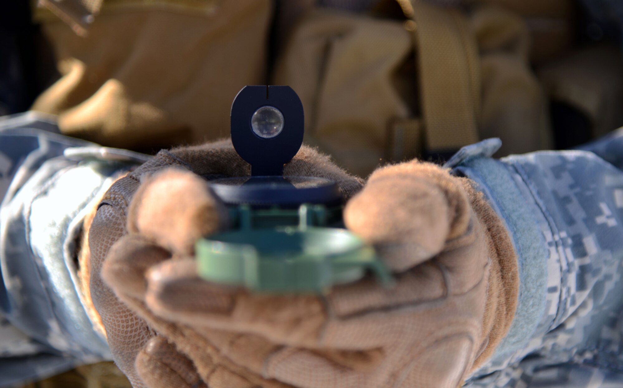Air Force Staff Sgt. Travis Hunt, 3rd Air Support Operations Squadron joint terminal attack controller, uses a M-1950 lensatic field compass to determine the directions to his objective location point at Joint Base Elmendorf-Richardson, Alaska, March 26, 2014. The compass has been widely used since late 1950.  (U.S. Air Force photo/Staff Sgt. Sheila deVera) 