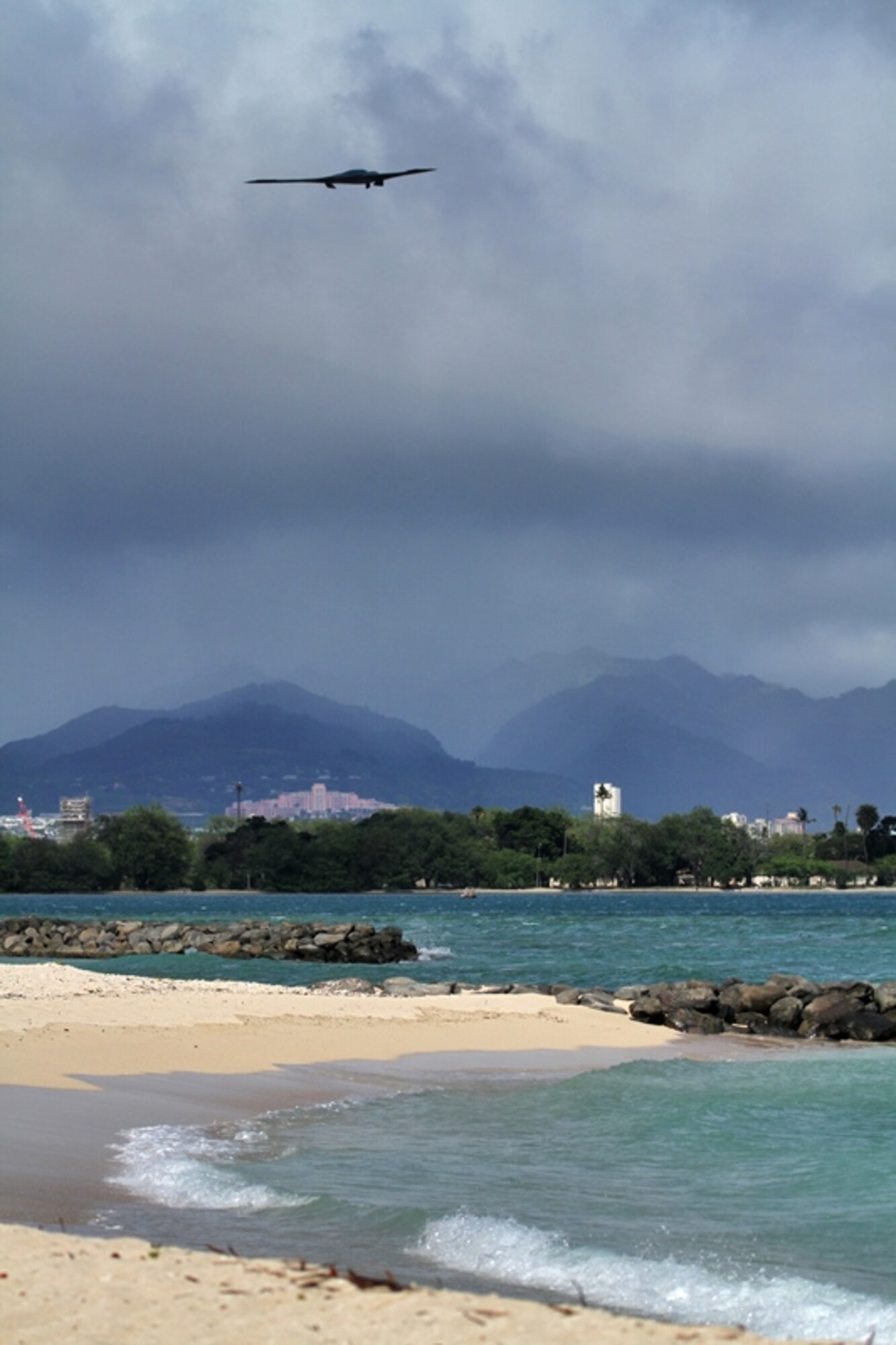 A B-2 Spirit strategic bomber conducts a low approach training flight over Joint Base Pearl Harbor-Hickam, Hawaii April 2, 2014.  Two B-52 Stratofortress strategic bombers from Barksdale Air Force Base, La. and two B-2 Spirit strategic bombers from Whiteman Air Force Base, Mo., flew non-stop from their respective home stations to training ranges within the vicinity of Hawaii and conducted range training operations and low approach training flights at Hickam AFB. (U.S. Marine Corps photograph by Staff Sgt. Jason Fudge)