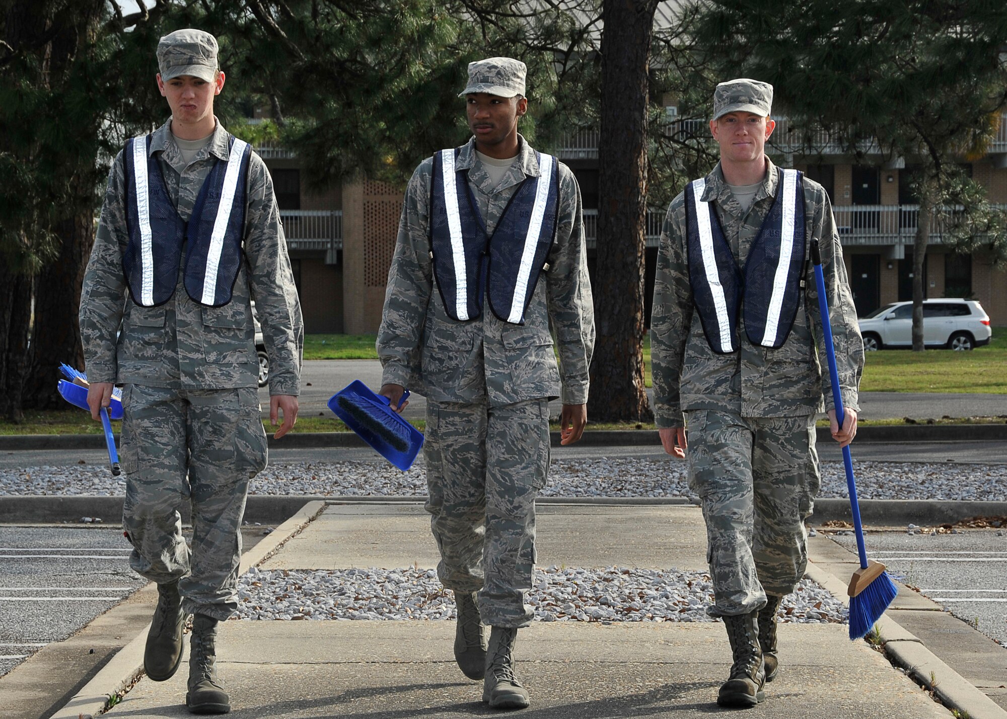 (From left to right) Senior Airman Michael Griffin, 325th Maintenance Squadron aircraft fuel systems, Airman 1st Class Eferm Baines, 325th Force Support Squadron food services, and Airman 1st Class Ben Kubesh, 325th MXS airfield ground equipment, head to a dormitory building April 3 for a detail. These Airmen are serving on a duty detail known as bay orderly. (U.S. Air Force photo by Airman 1st Solomon Cook)