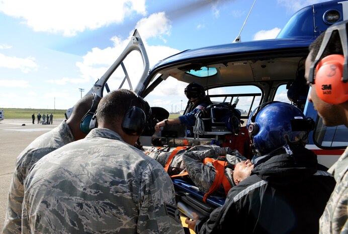 Beale Airmen and a flight crew from Enloe Emergency Services load a patient onto a helicopter during an exercise at Beale Air Force Base, Calif., April 2, 2014. The exercise enabled Airmen to gain proficiency loading patients onto emergency helicopters. (U.S. Air Force photo by Airman 1st Class Bobby Cummings/Released)