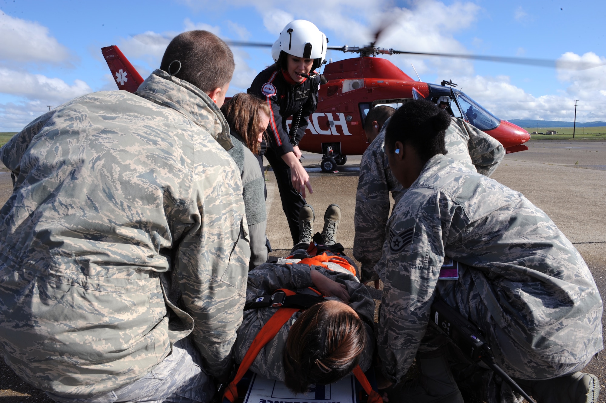 Airman 1st Class Amber Camerino, 427th Reconnaissance Squadron aerospace medical technician, is loaded on to a REACH Air Medical Services helicopter at Beale Air Force Base, Calif., April 2, 2014. The exercise allowed for Beale Airmen to gain proficiency loading patients onto emergency helicopters. (U.S. Air Force photo by Airman 1st Class Bobby Cummings/Released)
