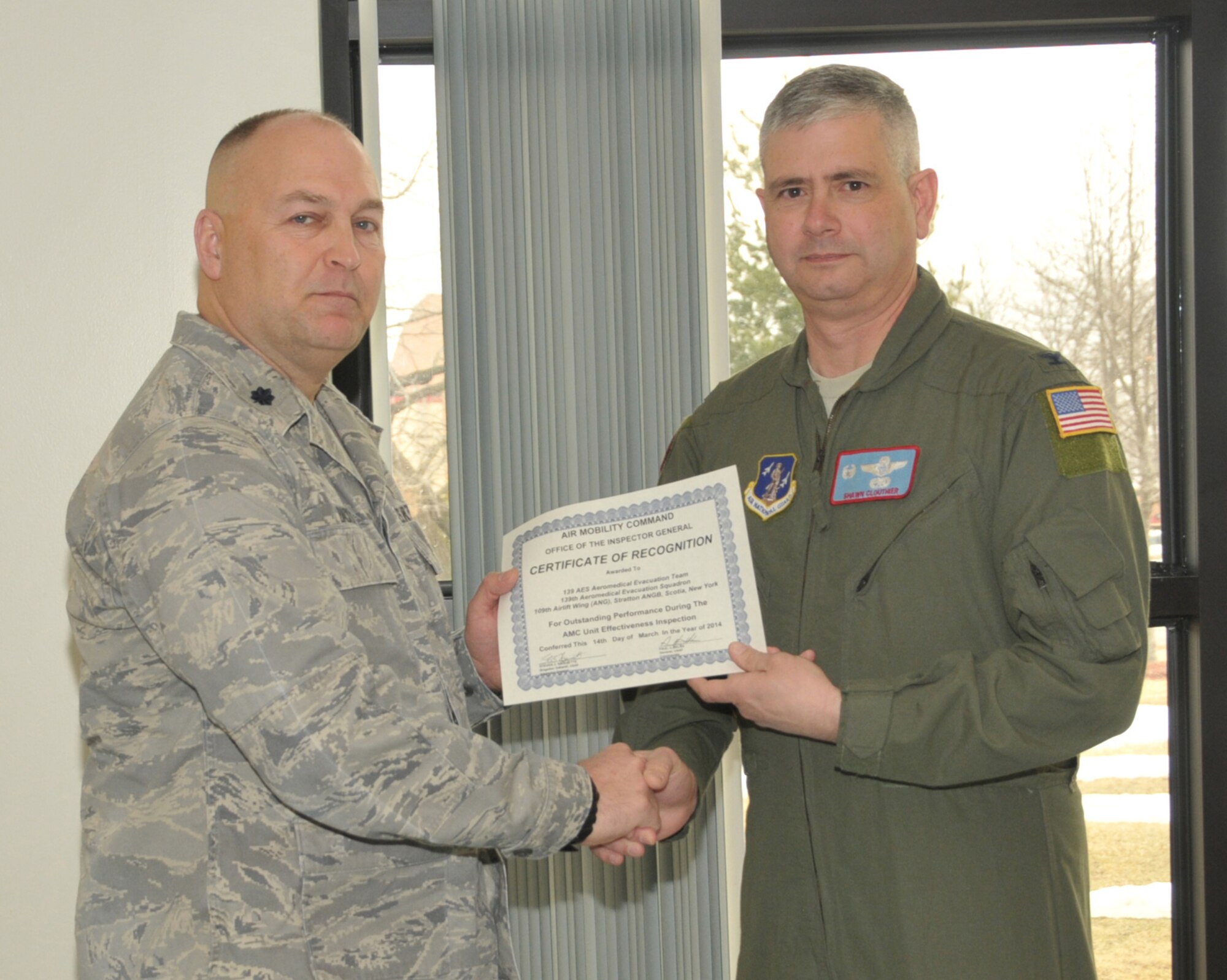 STRATTON AIR NATIONAL GUARD BASE, N.Y. -- Col. Shawn Clouthier (right), 109th Airlift Wing commander, presents Lt. Col. Brian Backus, 139th Aeromedical Evacuation Squadron commander, with a certificate of recognition March 25, 2014, from Air Mobility Command for outstanding performance during the 109th AW's recent Unit Effectiveness Inspection. The entire 139th AES Aeromedical Evacuation Team was recognized as an exceptional performer during the UEI. (Air National Guard photo by Master Sgt. William Gizara/Released)